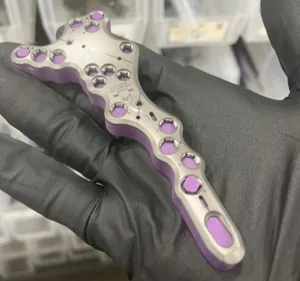 Physical fracture plate held in a gloved hand
