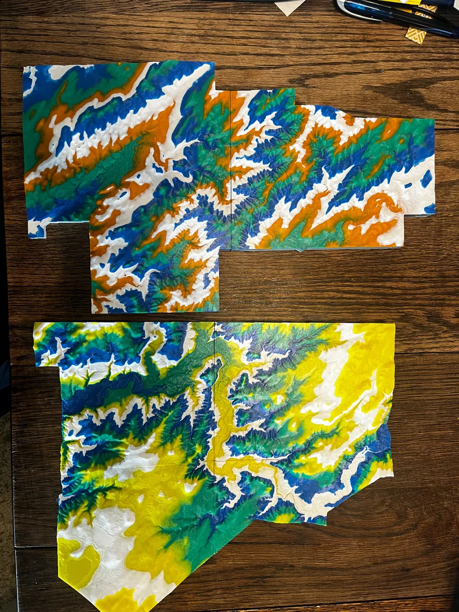 Large color-layered 3D-printed elevation map displayed on a table