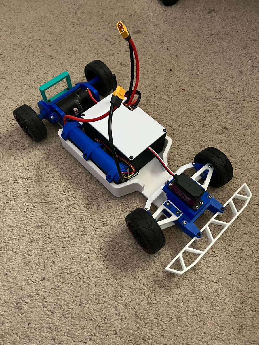 Completed blue 3D-printed RC car with exposed electronics